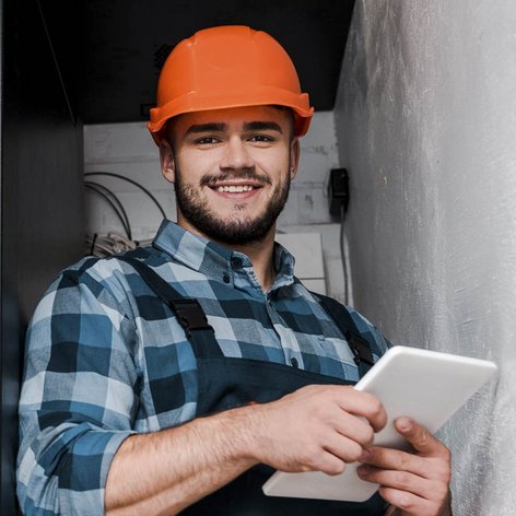 Ein Elektroniker der in einem Serviceraum ein Tablet bedient